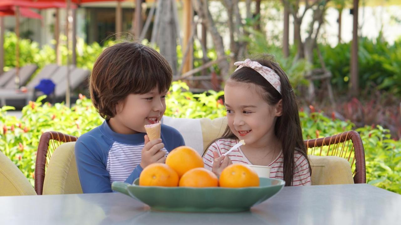 Hotel Amari Pattaya Exterior foto A boy and a girl eating fruit